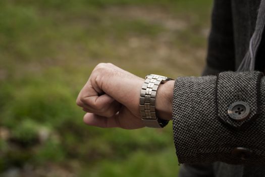 the man looks at her mechanical watch. Closeup of watch and the hand