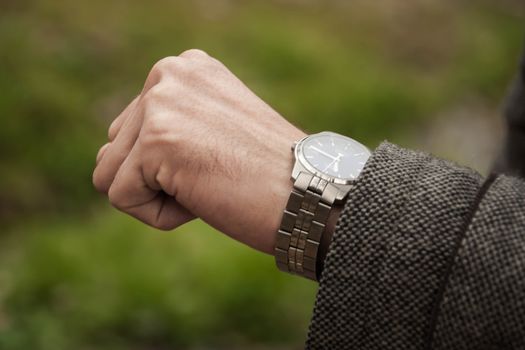 the man looks at her mechanical watch. Closeup of watch and the hand