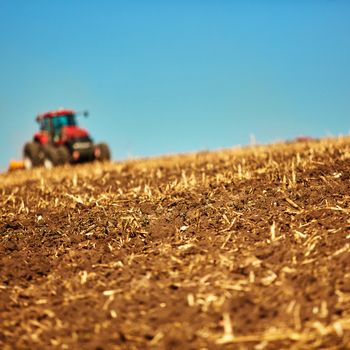 Agricultural Landscape. Tractor working on the field. Spring sunny day