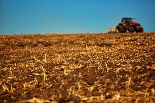 Agricultural Landscape. Tractor working on the field. Spring sunny day