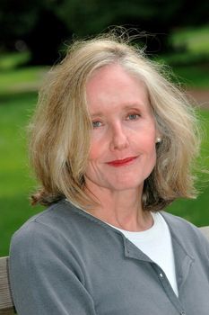 Mature female beauty relaxing on a park bench outdoors.