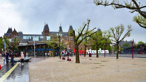 Amsterdam, Netherlands - May 6, 2015: Tourists at the famous sign "I amsterdam" at the Rijksmuseum in Amsterdam on May 6, 2015. Amsterdam is a capital and largest city of Netherlands.