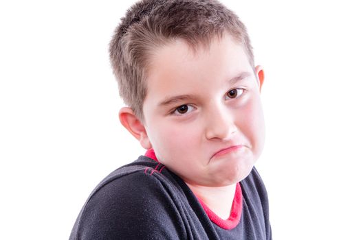 Head and Shoulders Close Up Portrait of Young Boy with Brown Eyes Looking at Camera with Down Turned Mouth in Studio with White Background