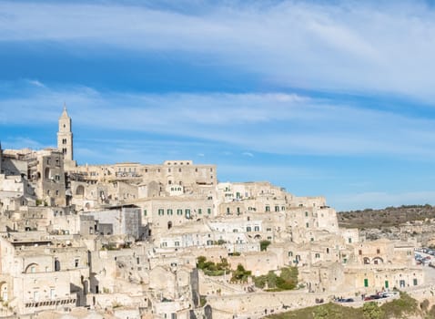 panoramic view of tipical stones and church of Matera under blue sky. Basilicata, Italy