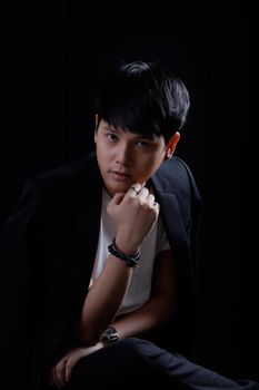 Portrait of Asian young man on black background