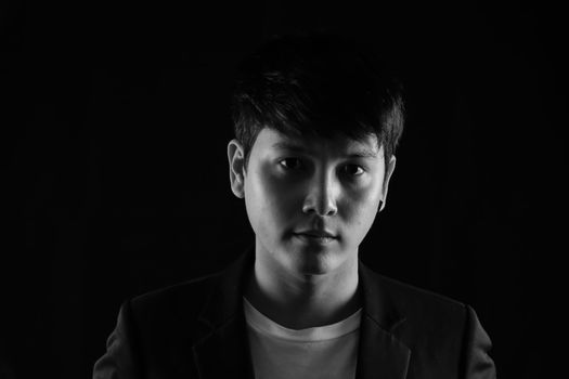 Portrait of Asian young man on black background