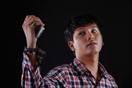 Portrait of Asian young man on black background