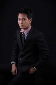 Portrait of Asian young man on black background