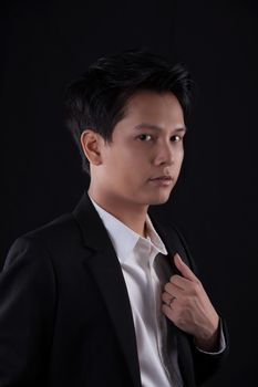 Portrait of Asian young man on black background