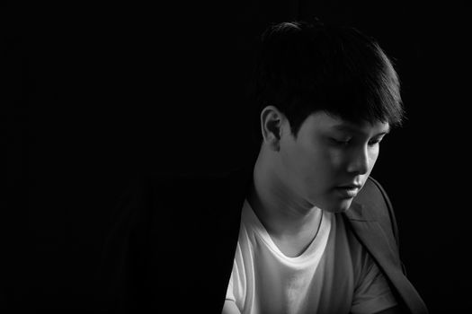 Portrait of Asian young man on black background