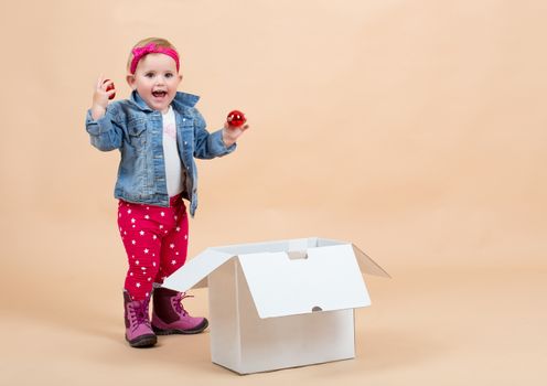 portrait of young cute baby on beige background with white paper box