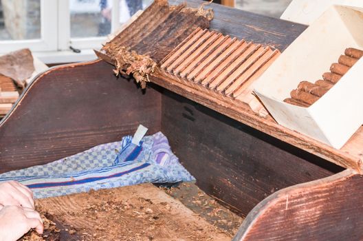 Production and processing of tobacco leaves with simple tools order to produce cigars.