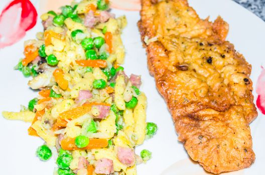 Noodles, peas and carrots with fried sea fish.