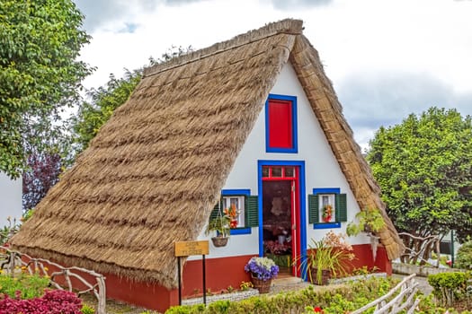 Santana, Portugal - June 7, 2013: Flower's related craft souvenir shop built like a typical triangular house, Island of Madeira.