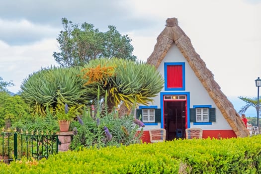 Santana, Portugal - June 7, 2013: Flower's related craft souvenir shop built like a typical triangular house, Island of Madeira.
