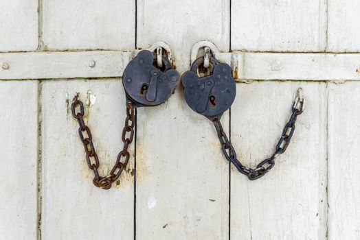 Two vintage locks on a white door