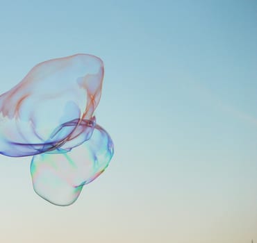 Soap bubbles on a blue sky illuminated by the sun texture background with copyspace