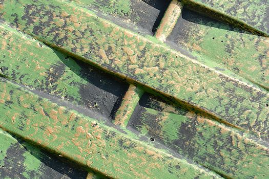 Green metal texture with patches of rust steel on its surface, taken outdoor