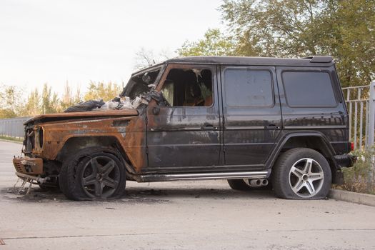 Burnt expensive SUV stands alone in the parking lot