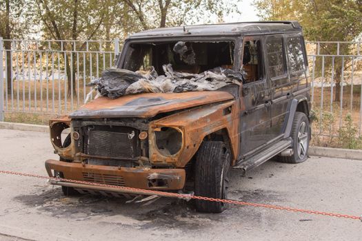 Burnt expensive SUV stands alone in the parking lot