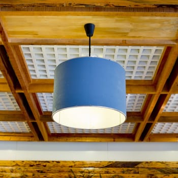 Modern blue hanging lamp on wooden ceiling