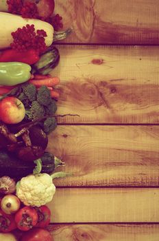 Frame of Various New Harvest Vegetables, Fruits, Roots, Edible Mushrooms and Berries closeup on Wooden background. Retro Styled