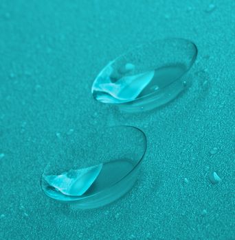 Two Contact Lenses with Water Droplets closeup. Turquoise Toned