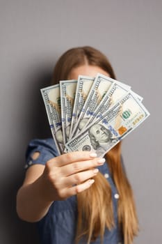 Fan of 100 dollar banknotes in beautiful woman hands