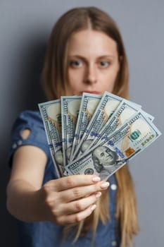 Fan of 100 dollar banknotes in beautiful woman hands