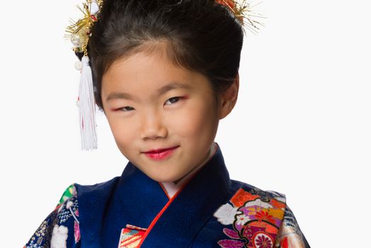 A cute young Japanese girl wearing a Kimono on a white background.