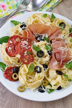 Pasta with gammon, olives, sun-dried tomatoes and parmesan