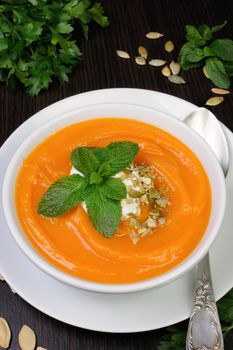 Pumpkin soup with sour cream sauce flavored  pumpkin seeds  and mint