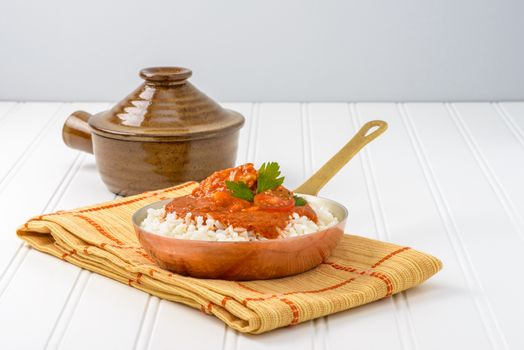 Pan of Indian butter chicken served with white rice.