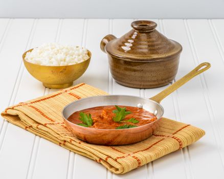 Pan of authentic Indian butter chicken served with rice.