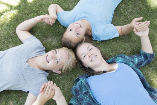 Three Girls Lying on The Green Grass