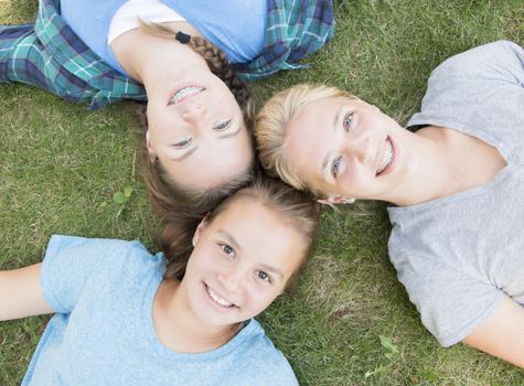 Three Girls Lying on The Green Grass