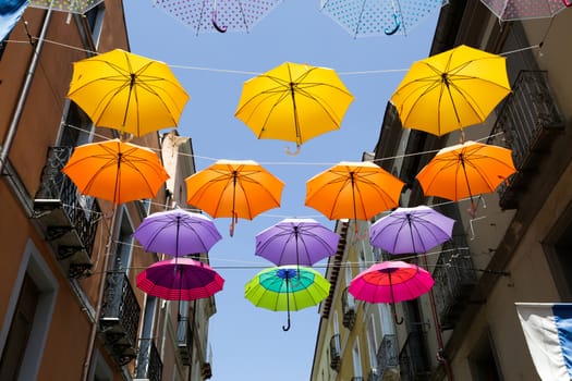 Colored parasols in the streets of Iglesias, Sardinia, Italy