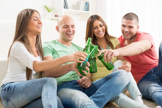 Friends enjoying with beer and cheers together at home party.