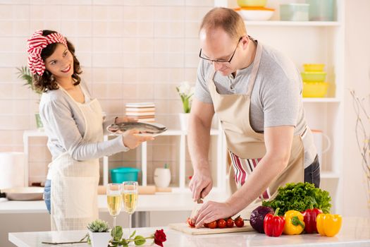 Happy couple preparing food in the kitchen