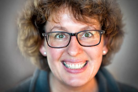 Closeup image of a laughing happy woman with glasses