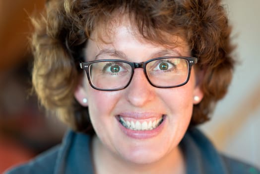 Closeup image of a laughing happy woman with glasses