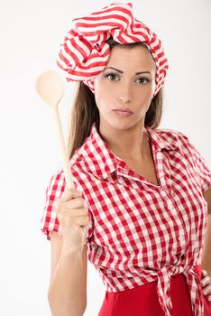Beautiful serious young woman holding mixed spoon. Looking at camera. White background.