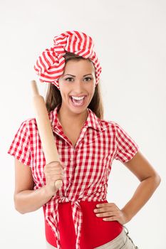 Beautiful serious young woman holding rolling pin. Looking at camera. White background.