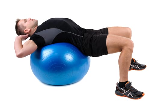 Young man shows starting position of Abdominal Fitball Workout, isolated on white