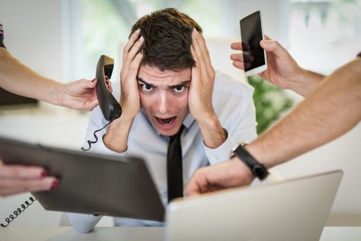 Stressed busineessman sorounded with many jobs.