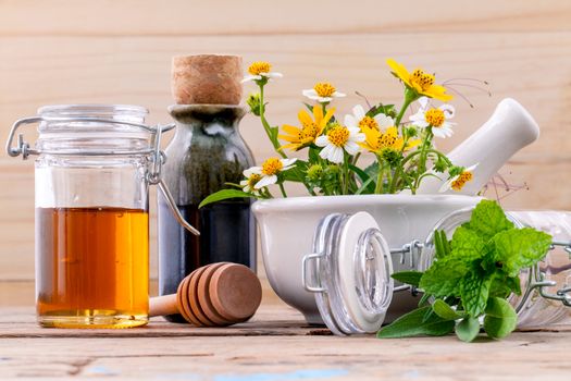 Alternative health care fresh herbal ,honey and wild flower with mortar on wooden background.