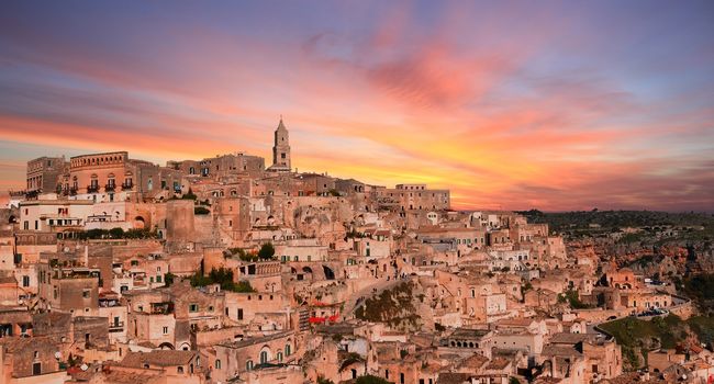 panoramic view of typical stones and church of Matera under sunset sky. Basilicata, Italy
