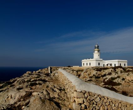 Lighthouse Far de Cavalleria on Blue Sky background on Mediterranean Shore of Menorca, Balearic Islands