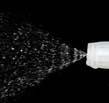 Water Spray Nozzle spraying water with a black background behind it.