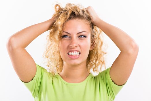 Portrait of beautiful pouty young woman stressing and holding his head. White background